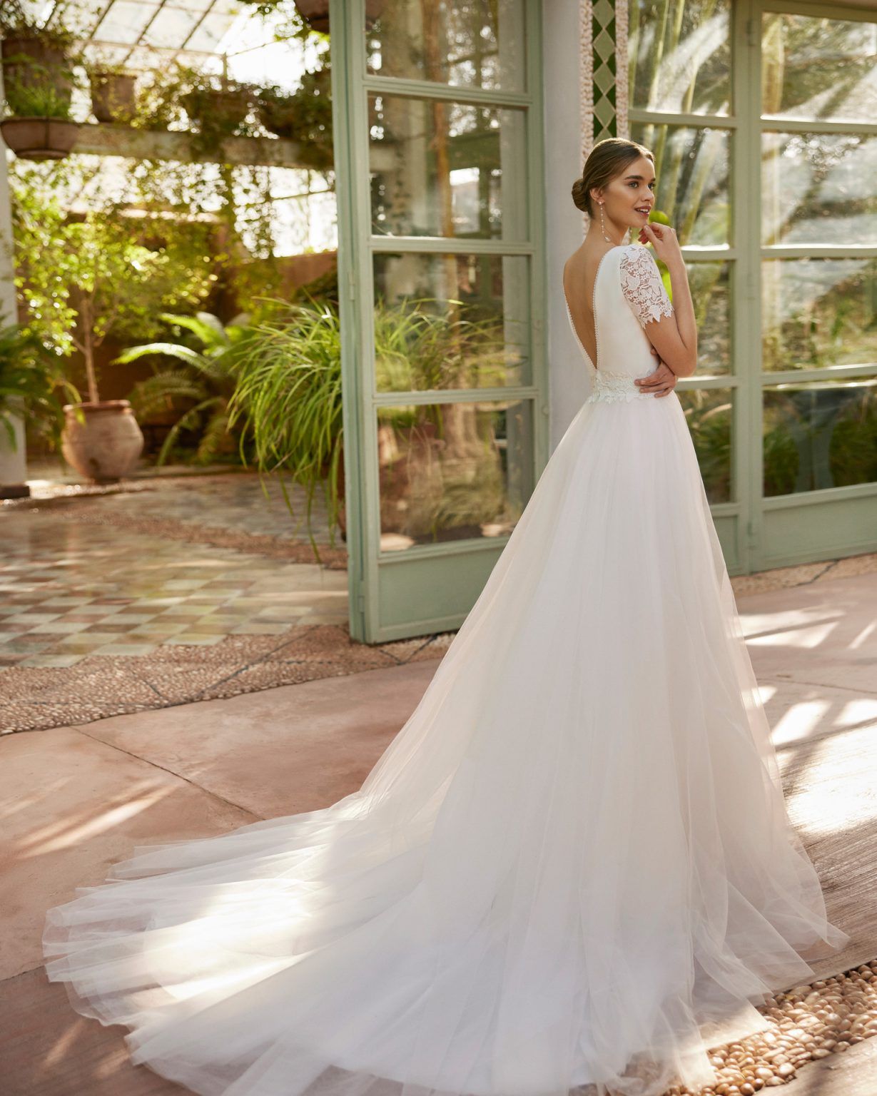 Vestido de noiva romântico tipo princesa, com corpete em crepe e saia em tule. Possui decote em V, costas em V, mangas em renda guipure e saia com fenda lateral. Um design exclusivo da Alma Novia.